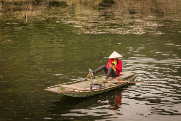 Mit den Füssen paddelnde Asiatin mit Reishut und Smartphone in der Hand9