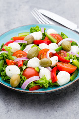 Vegetable salad with cheese mozzarella, tomatoes, basilikum and spice.