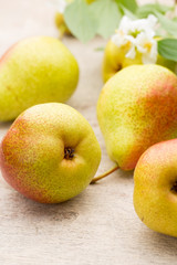 Fresh pears with leaves in a on wooden background.