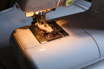 Close-up of a sewing machine with light on. workplace tailor. sewing industry