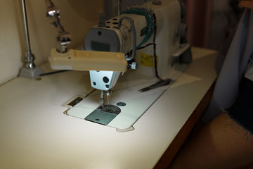 Close-up of a sewing machine with light on. workplace tailor. sewing industry