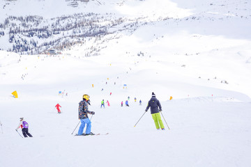 ski slope with skiers in the Alps