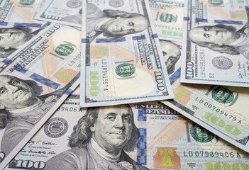 Obraz na płótnie Canvas US New $100 Bills Scattered on a Table