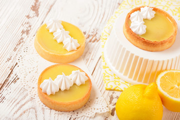 Lemon pie on the table with citrus fruits. Traditional french sweet pastry tart. Delicious, appetizing, homemade dessert with lemon curd cream. Copy space