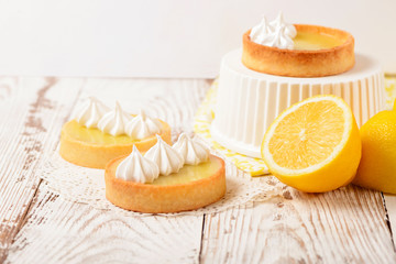 Lemon pie on the table with citrus fruits. Traditional french sweet pastry tart. Delicious, appetizing, homemade dessert with lemon curd cream. Copy space