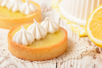 Obraz na płótnie Canvas Lemon pie on the table with citrus fruits. Traditional french sweet pastry tart. Delicious, appetizing, homemade dessert with lemon curd cream. Copy space