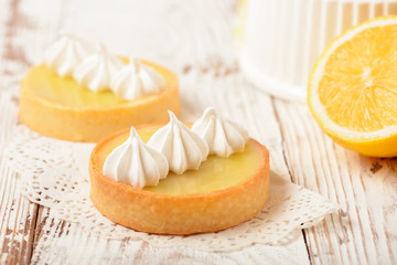 Lemon pie on the table with citrus fruits. Traditional french sweet pastry tart. Delicious, appetizing, homemade dessert with lemon curd cream. Copy space - obrazy, fototapety, plakaty