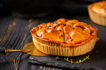 Meat mini pie on the wooden board on table background, closeup with copy space, rustic style