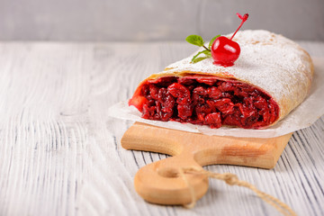 Sliced cherry strudel on a wooden board