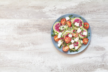 Healthy delicious tasty salad with tomatoes, radishes, cheeses, sprouts and sesame in plate
