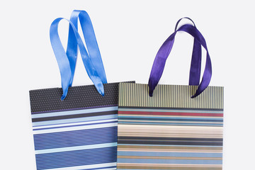 Striped paper bags for shopping. Paper carrier bags isolated on white background, cropped image.