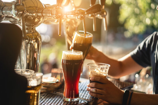bartender pours a dark beer close up