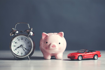 clock with piggy bank and car
