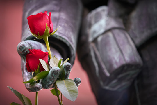 Close up Roses on Soldier Statue. Red roses on a close up of a statue of a world war one soldier.

