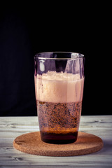 glass of beer, wooden table, foam, black background