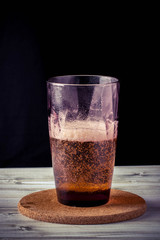 glass of beer, wooden table, foam, black background
