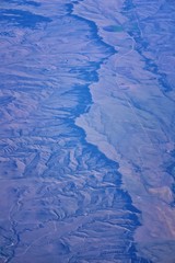 Fototapeta premium Aerial view of topographical landscapes over midwest states on flight over Colorado, Kansas, Missouri, Illinois, Indiana, Ohio and West Virginia during autumn. Grand sweeping views of crops, rivers, p