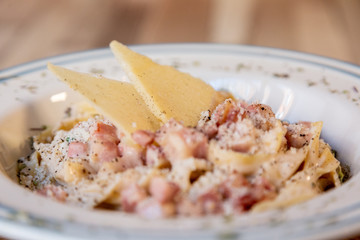 Close up of Carbonara spaghetti plate on a wooden table