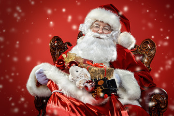 santa claus in armchair  with gifts