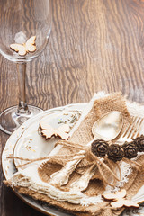 Fototapeta na wymiar Tableware and silverware with dry decorations, wooden background