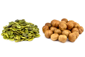 The peeled seeds of pumpkin and hazelnut. Isolated.