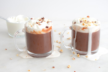 Hot chocolate topped with whipped cream and chopped hazelnuts