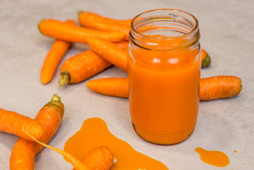 Carrots and fresh juice on the grey concrete table