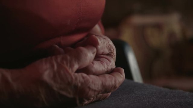 Old woman holding her hands together