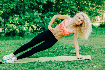 Fototapeta premium Image of young curly-haired sports woman practicing yoga on rug 