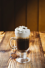 Irish coffee in glass on wooden table