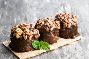 Sticky chocolate and walnut puddings on wooden table