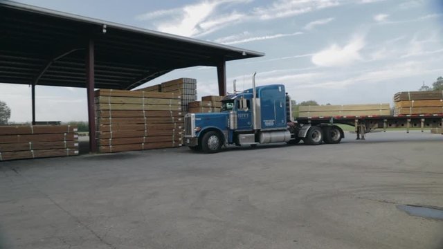 Peterbilt Semi Truck turning in lumber yard pulling trailer