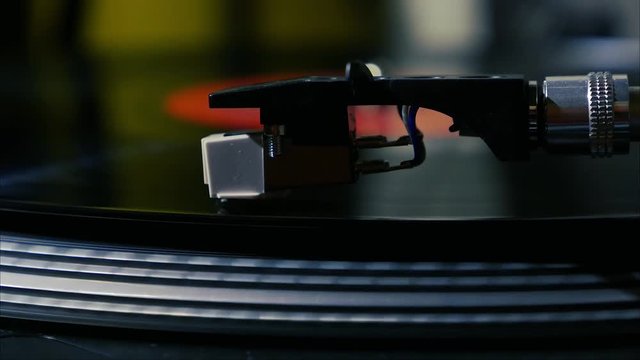 A needle is put down on the spinning black vinyl on the turntable