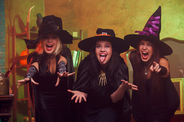 Obraz premium Picture of screaming three witches in black hats with arms outstretched