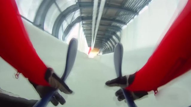 the athlete on the sledge goes down on a bobsleigh track