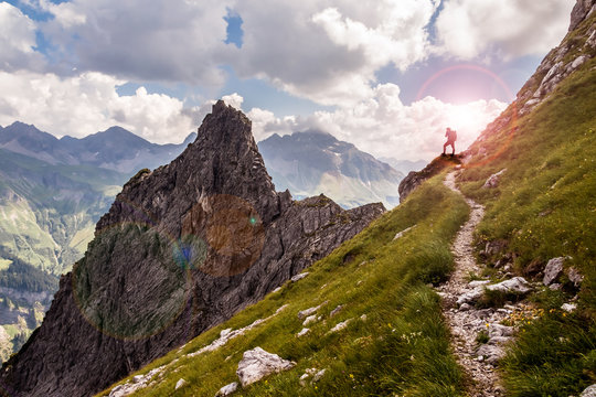 Single Hiker on a Narrow Mountain Path in the Sunlight
