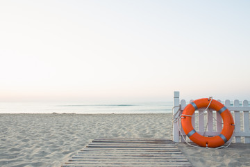 morning warm sunrise near the sea with wooden leg boards, wooden fence and orange saving pitch