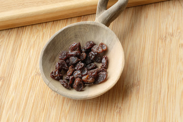 Raisins on a wood spoon.