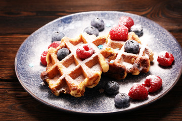 waffles with fresh blueberries, sugar and raspberries.