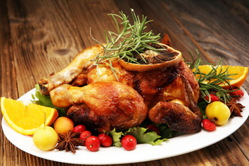 Baked turkey or chicken. The Christmas table is served with a turkey, decorated with fruits, salad and nuts. Fried chicken, table. Christmas dinner