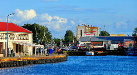 Fototapeta na wymiar Ustka, Pomerania, Poland - Ustka seaport peers and ships and the Baltic Sea shoreline