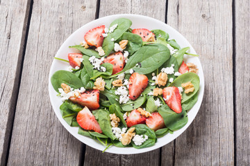 Strawberry salad with spinach , cheese and walnut . Healthy food