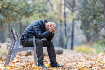Autumn sadness and depression in the park on the bench