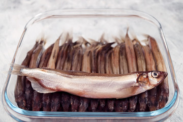 Small sea fish, sprat, laid tightly on the bottom of glassware.