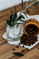 Olive branches and coffee on a wooden rustic background