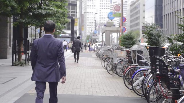 Salarymen in suits crossing street in Tokyo in slow motion