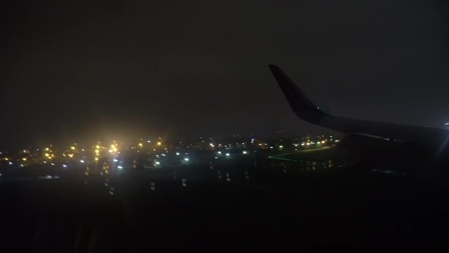 The plane lands at the airport at night (inside view)