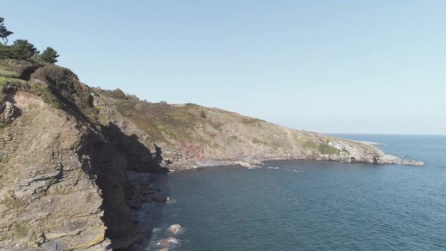 Aerial drone shot flying along south devon coast path near thatcher rock, Torbay, England
