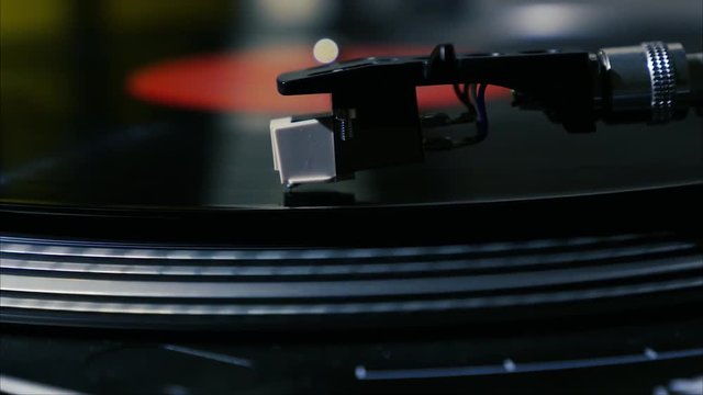 A needle is put down on the spinning black vinyl record on the turntable