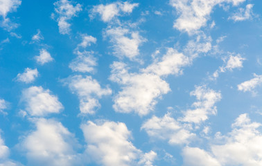 Blue bright summer sky with fluffy clouds on a sunny day
